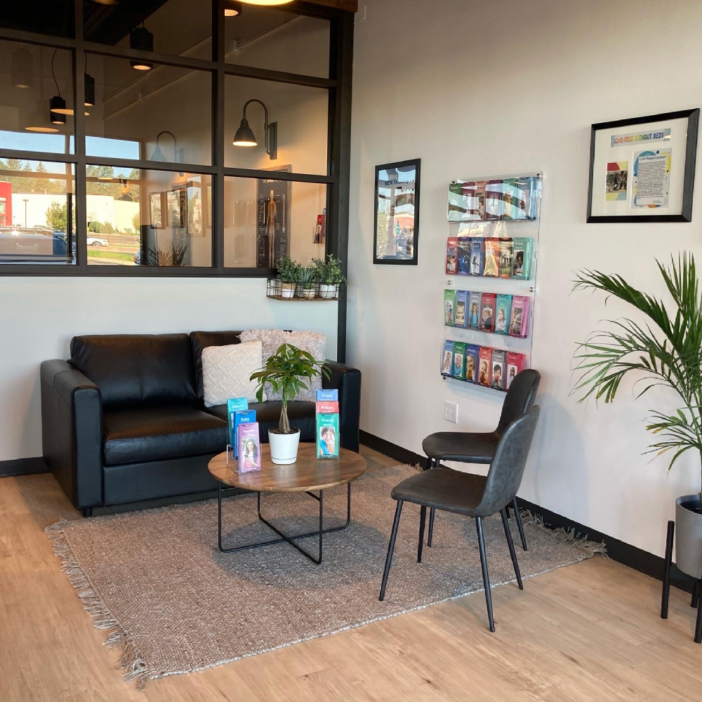 Lobby area at a family-owned chiropractor in Colorado Springs with seating, plants, and informational displays.